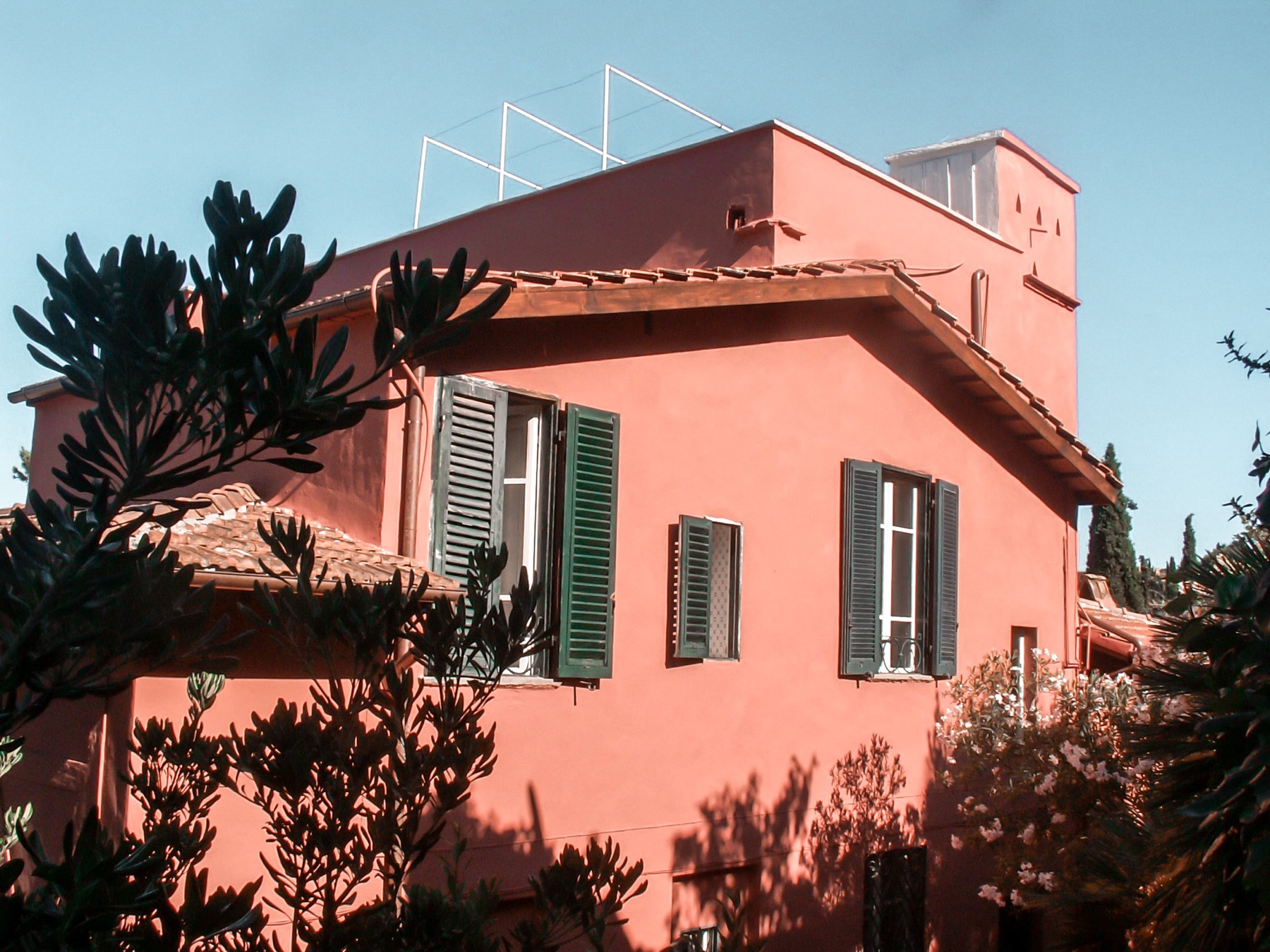 A corner of the villa, with green shutters on the pink walls